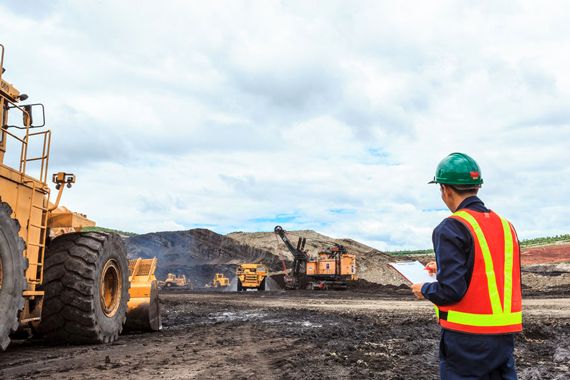 Des camions transportent du minerais dans une mine à ciel ouvert.