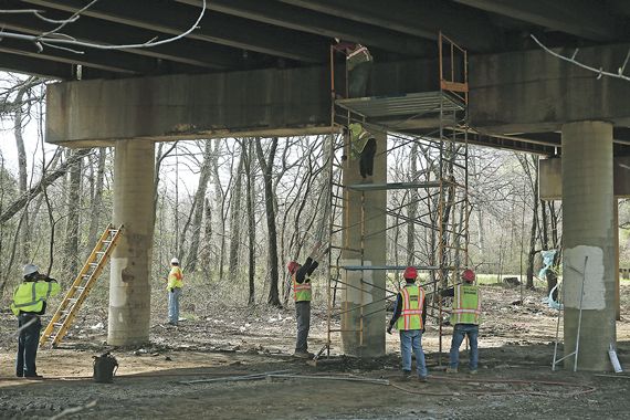 Des cols bleus travaillent sur la structure d'un pont.