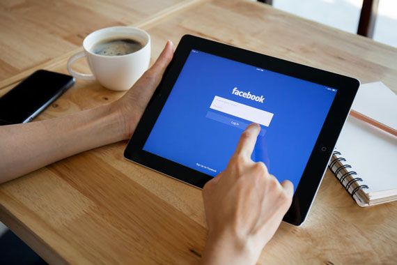 Quelqu'un consulte l'application de Facebook sur une tablette