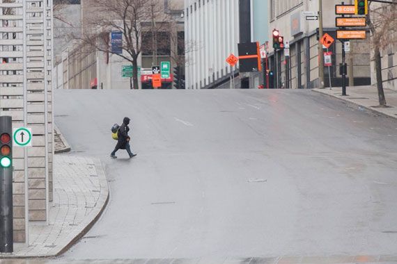 Une femme traverse une rue du Centre-Ville de Montréal