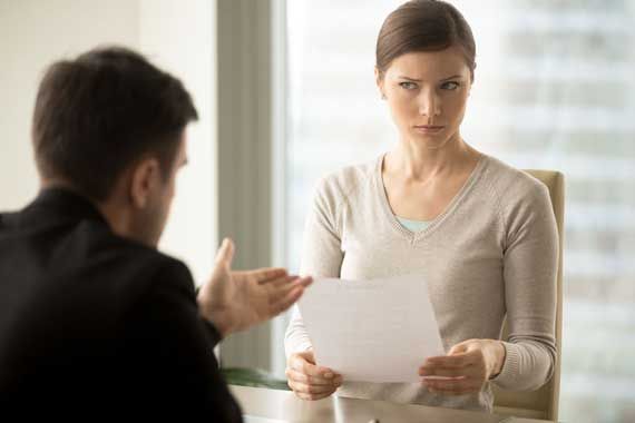 Une femme montrant qu'elle n'a pas confiance envers un homme devant elle.