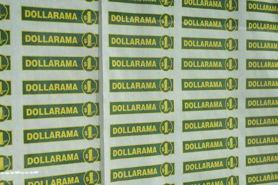 Un mur placardé d'autocollants de Dollarama