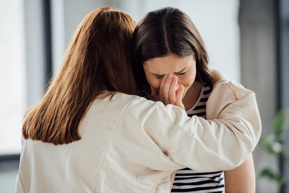 Une femme en sert une autre dans ses bras.