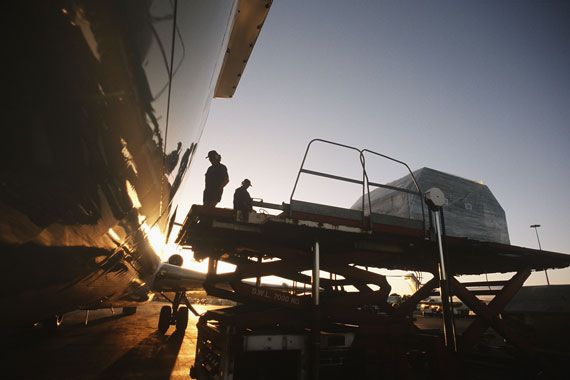 Des employés remplissent un avion de bagages