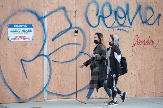 Deux femmes avec des masques marchent dans la rue