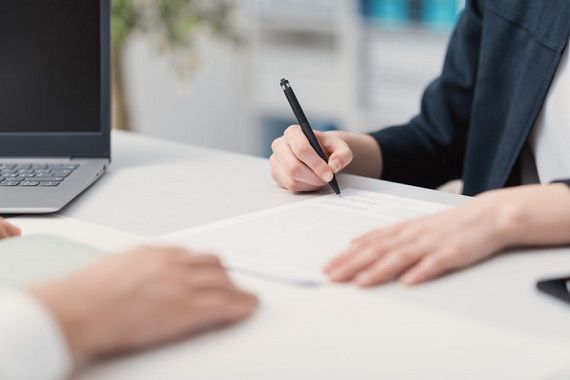 Une femme signe un chèque