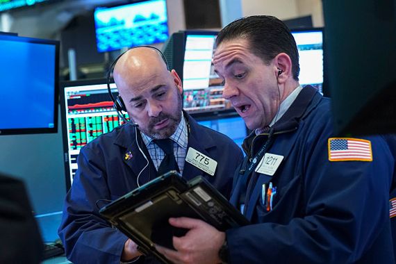 Des hommes consultent un tablette à la Bourse.