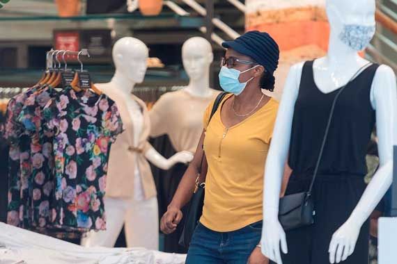 Une personne masquée dans une boutique de vêtements