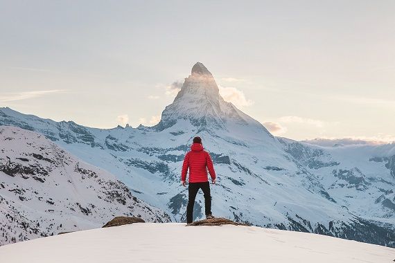 Une personne contemple le sommet d'une montagne.