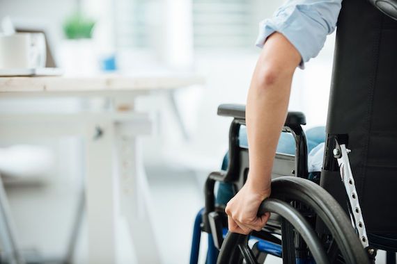 Une personne assise sur un fauteuil roulant dans un bureau