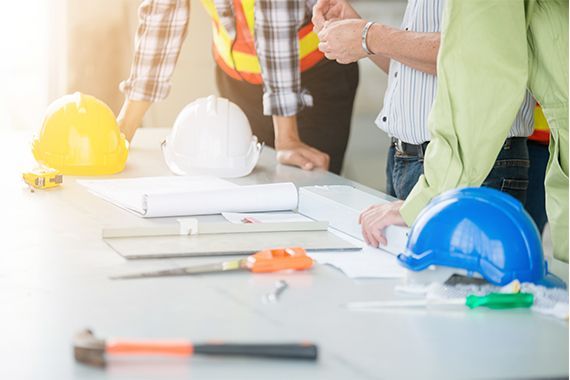 Trois employés de la construction autour d'un plan.