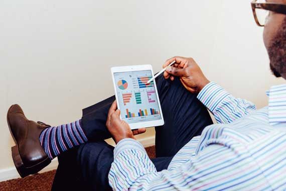 Un homme qui regarde une série d'indicateurs sur une tablette.