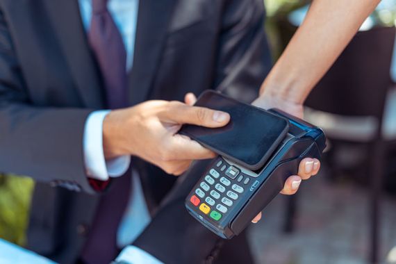 Uns personne qui fait un paiement avec son téléphone mobile.