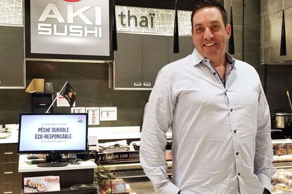 Un homme devant un comptoir à sushis