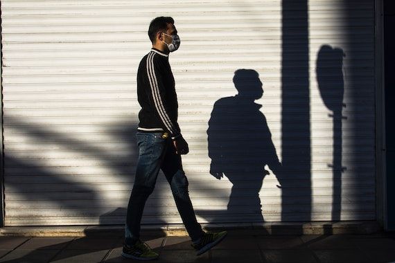 Un homme marche dans la rue avec son masque