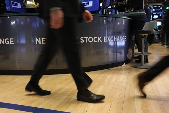 Des gens marchent devant un symbole de la Bourse de New York