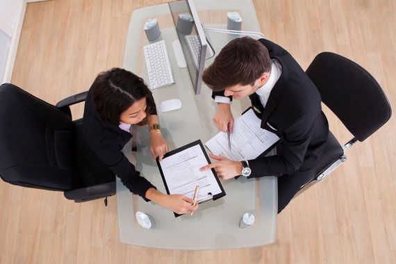 Deux personnes qui remplissent des demandes d'emplois. 