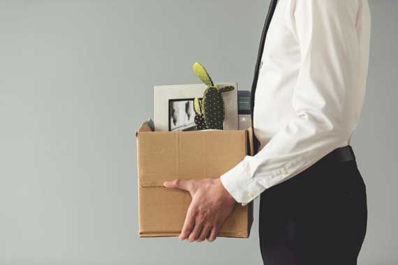 Un homme qui quitte son bureau avec ses effets personnels.