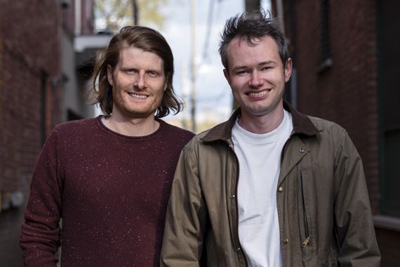 Deux hommes sourient.