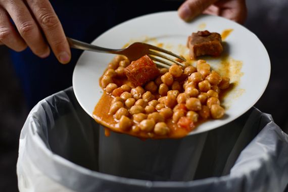 Une personne jette de la nourriture d'un plat