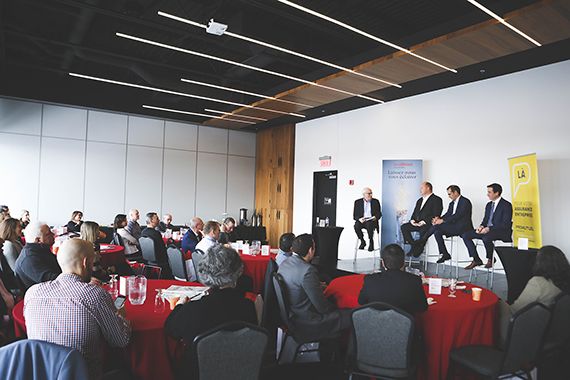 Des gens dans une salle, écoutant un panel d'experts.