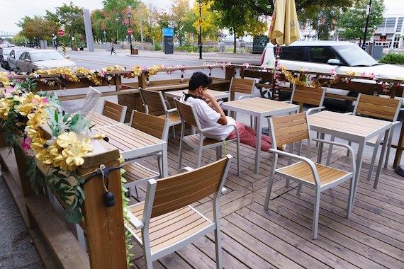 Une personne assise à une table d'une terrasse