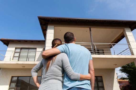 Un couple devant une maison