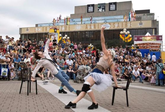 Des artistes qui font un numéro devant des festivaliers.