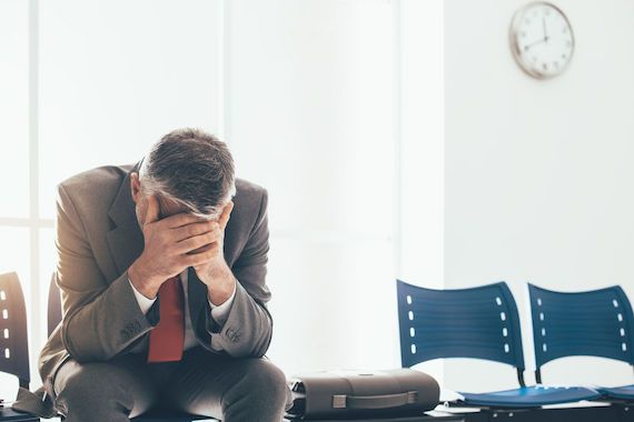 Une personne se tient la tête dans une salle 