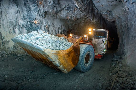 Une pelle mécanique qui transporte des cailloux dans une mine