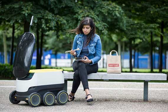 Un robot Just Eat effectue une livraison à une dame.