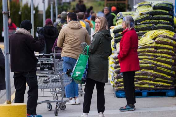 Une file devant un magasin d'alimentation et de produits pour la maison.