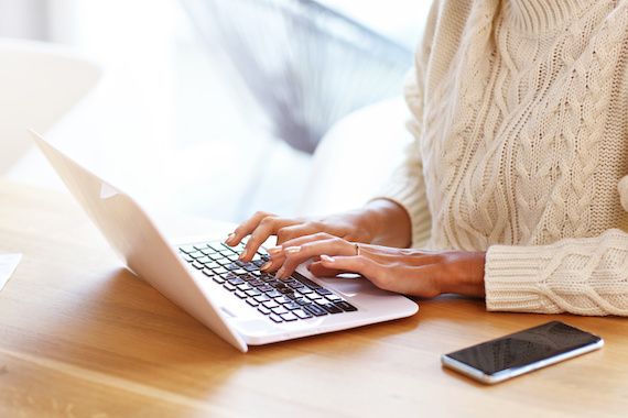 Une femme travaille de la maison sur son ordinateur portable.