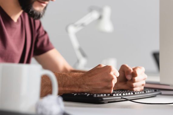 Un homme frappe sur son clavier