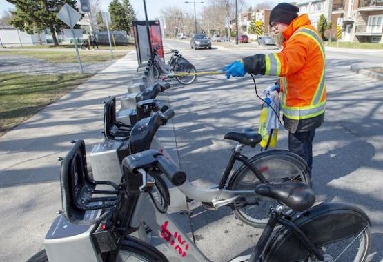 Un employé entretient un BIXI à une borne.