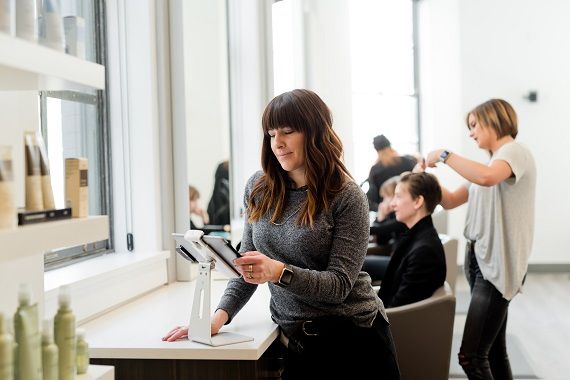 Une femme règle sa note à une caisse libre service