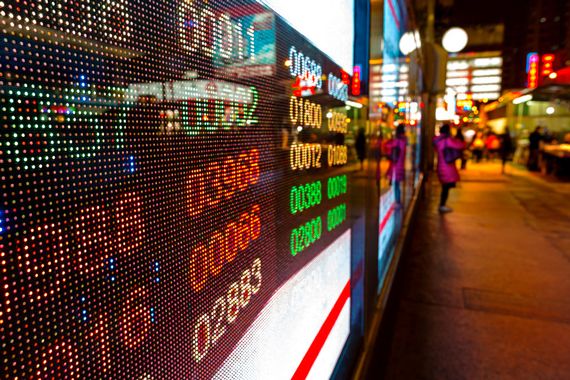 Un tableau numérique qui affiche le marché des stocks devant un bâtiment à Hong Kong.