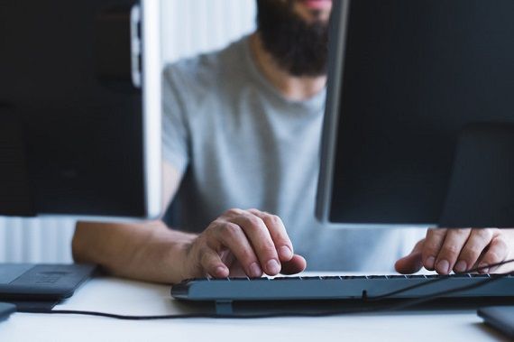 Un homme consulte deux écrans