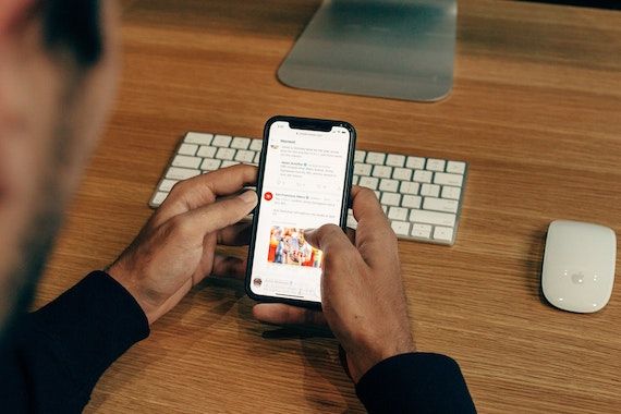 Un homme consulte un réseau social sur son téléphone cellulaire