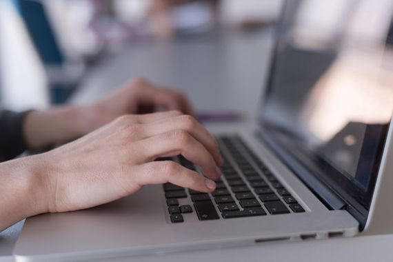 Des mains écrivent sur un clavier d'ordinateur